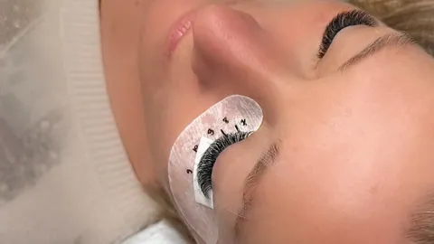 Vue des deux yeux pendant une pose d’extensions chez Nataliia